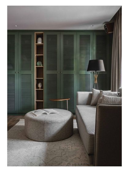 For this home theater, we used a comfortable daybed and a large ottoman. The deep green louvered wardrobe adds a bold design element to the room.