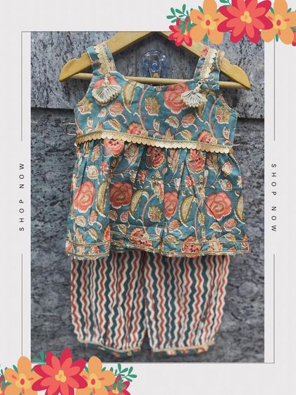 This charming Indian kurta set features a floral print top with tassel details and striped dhoti-style pants. The elastic waistband ensures maximum comfort for your little princess.