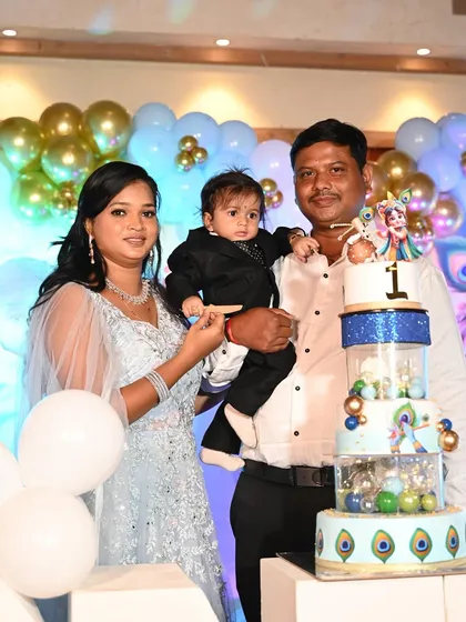 The family gathers for a photo with their son and his impressive multi-tier Krishna cake.