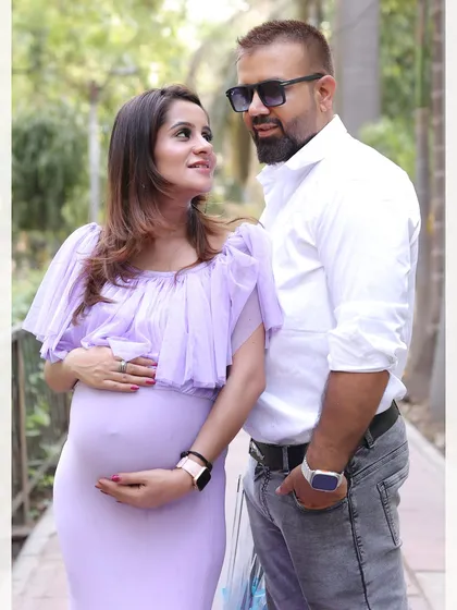 A close-up shot of an expecting couple sharing a look during their outdoor maternity session in a park.