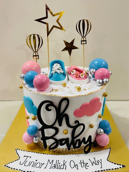 "Oh Baby!" A fun and festive baby shower cake with pink and blue clouds and balloons, topped with adorable fondant baby shoes and hot air balloon toppers.