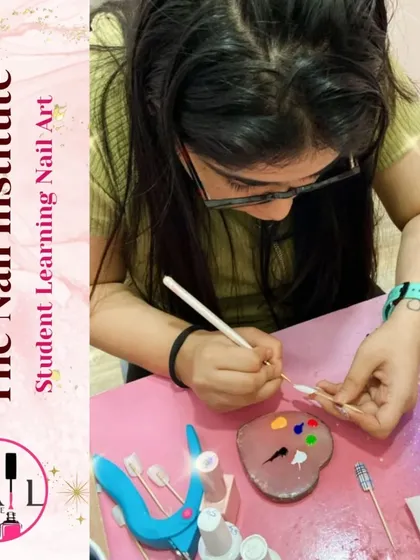 This student is using a palette to mix colors for her nail art, learning about color theory and custom blending.