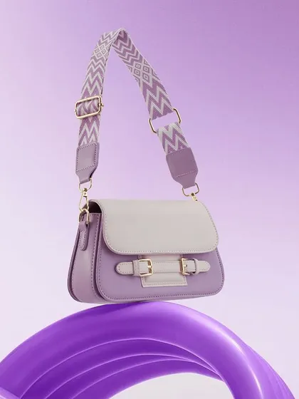 A playful and modern shot of a lavender handbag balanced on a swirling purple prop. The vibrant, monochromatic color scheme is eye-catching and perfect for a trendy, youthful brand.