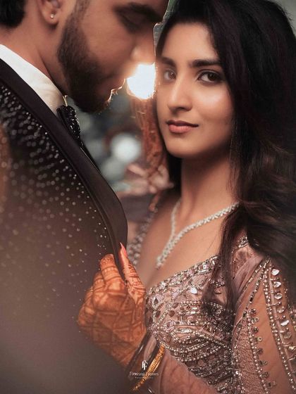 A backlit close-up of the couple, with the sun setting behind them, creating a beautiful, warm glow.