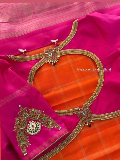 A beautiful back cutout design on a pink blouse, accentuated with jewellery-style pendants. The combination of sheer net and intricate embroidery is a modern take on traditional bridal wear.