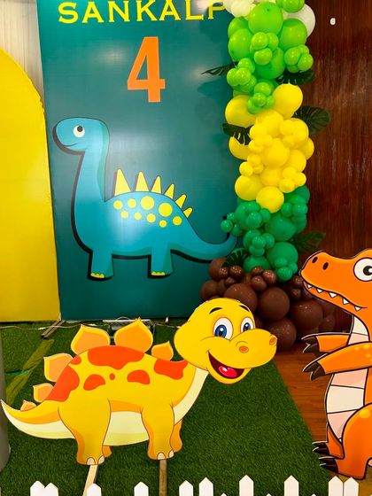 A close-up of the dinosaur cutouts and themed backdrop. I use high-quality printed props to bring the theme to life and create great photo opportunities for the kids.