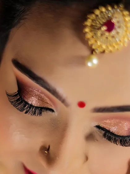 A close-up of this gorgeous shimmery eye makeup for a reception look. We'll cover how to properly layer eyeshadows, apply false lashes, and create a winged liner that stays put, giving you the confidence to create detailed eye looks.