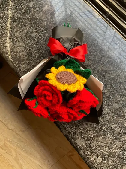 A classic combination of red roses and a single sunflower. The black and white wrapping with a bright red ribbon makes this a bold and beautiful gift.