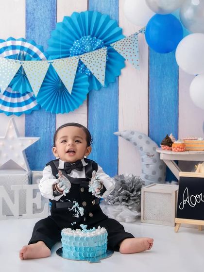 The moment of truth. This little boy dives right into his first birthday cake, a perfect capture of his curious and playful nature.