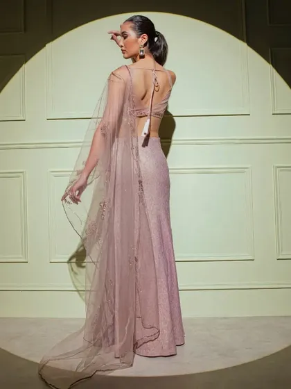 The back view of the mauve fish-cut gown, highlighting the delicate embroidery on the sheer cape and the elegant tie-back blouse.