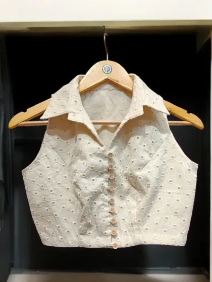 Elevate your saree style with this unique collared halter blouse. It's a modern, trendy cut crafted from delicate chikankari fabric, designed to complement and enhance the beauty of any saree.