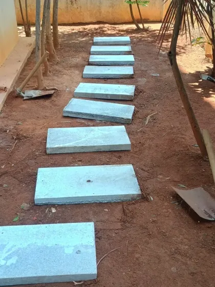 The stone pavers for the pathway are now laid out. The next step is to fill the surrounding area with soil and grass.