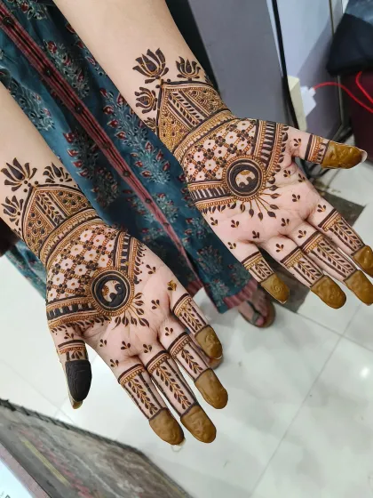 This is a beautiful example of Rajasthani-style bridal mehndi, featuring elephant motifs in the center of the palms. The rest of the design is filled with fine lines and traditional patterns.