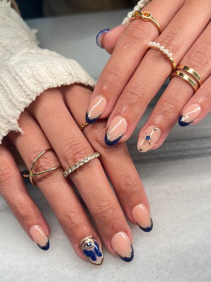 The full view of the blue and gold abstract French manicure. The combination of the classic French shape with modern, artistic details makes this set truly special.