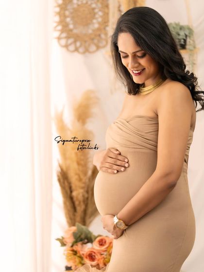 The soft smile and gentle hold on the belly make this a heartwarming and authentic portrait.