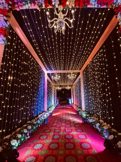 The entrance to the fairy light tunnel, framed with flowers and a crystal chandelier, promising a magical journey inside.