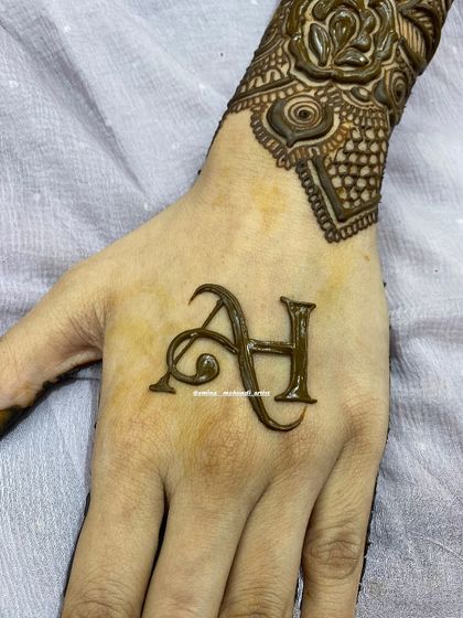 Elegant 'A' and 'H' initials for a personalized henna tattoo.
