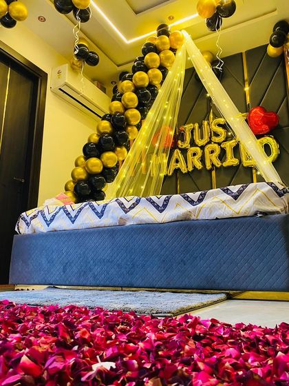 A low-angle view showcasing the dense carpet of rose petals, part of the black and gold "Just Married" surprise decoration.