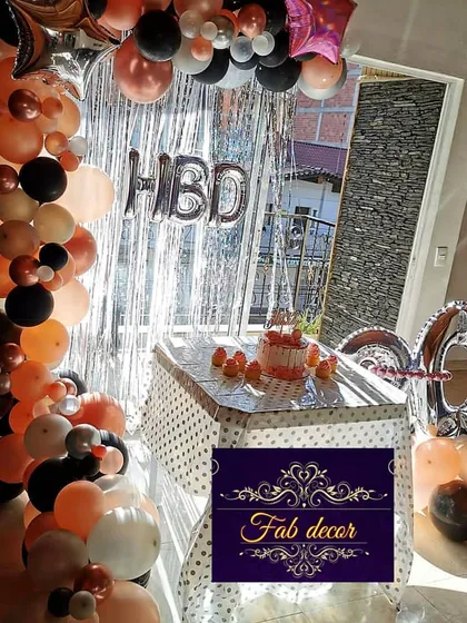 Balloon decorations are great for any age. Here is a 40th birthday party setup I did in a client's home, featuring a stylish balloon arch over the cake table in peach, black, and white, with large "40" foil balloons.