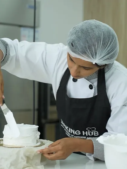 Focus and precision are key in baking. This student is carefully applying frosting to her cake, a technique she practiced and perfected during our 5-day masterclass. It's all about building confidence through practice.