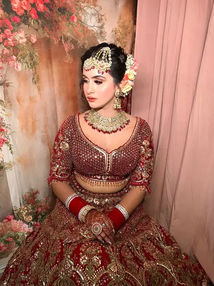 A full-length shot of the bride, showing how the heavy jewelry balances her ornate lehenga.