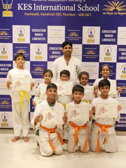 A group of orange and yellow belt students from KES International School, ready to take on the next stage of their training.