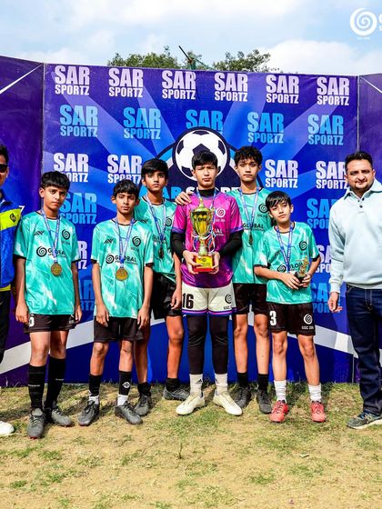 Our U13 team and coaches pose with their runners-up trophy, celebrating a fantastic performance in the tournament.