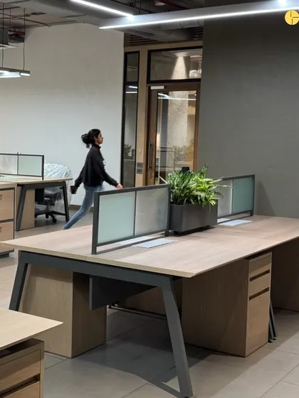 A view of the open-plan workstations at 'Project LH.' The design uses clean lines and a combination of wood and metal for the desks, with low partitions that allow for both individual focus and easy team collaboration.