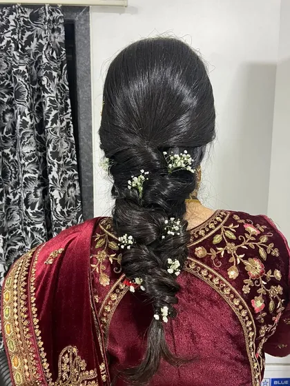 An elegant bridal braid for a wedding ceremony. This intricate braid is woven with sprigs of baby's breath for a delicate and timeless look.