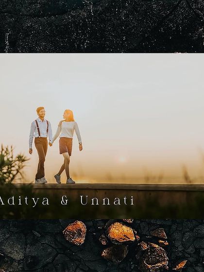 A minimalist and elegant pre-wedding photo of a couple walking along a wall at sunset.