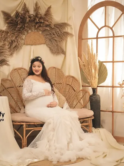 Another beautiful shot of the mom-to-be on the wicker sofa. The combination of the white lace dress and the natural textures of the set is simply perfect.