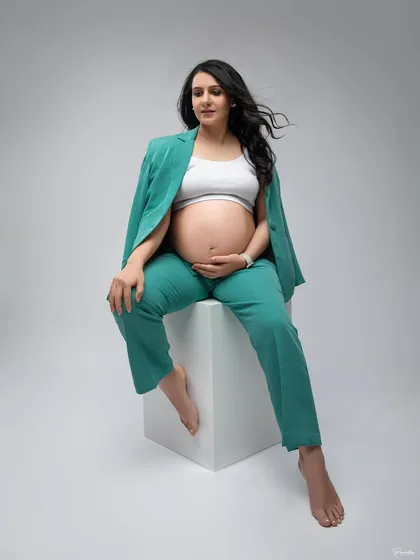 Maternity photos can be modern, chic, and powerful. This expecting mother chose a stylish green pantsuit from my collection, showing that pregnancy portraits can reflect your personal style, whether it's classic, bold, or contemporary.