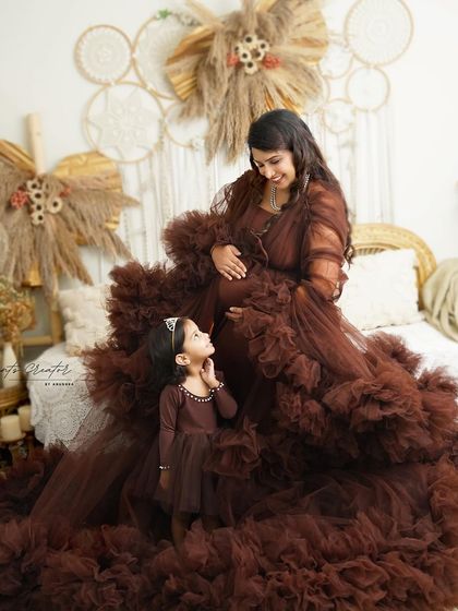 A sweet mother-daughter moment. The little girl looks up at her pregnant mother with admiration and love, a precious memory captured forever.