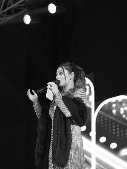 A black and white photo capturing my focus on stage. Hosting is about more than just speaking; it's about feeling the room and guiding the experience.