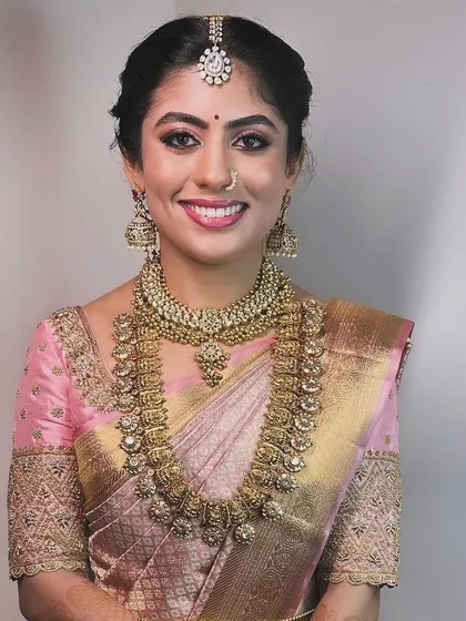 A duplicate of image 126, a portrait of the bride in her pink saree, highlighting the detailed craftsmanship of the blouse.