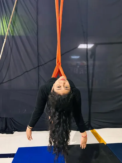 Looking at the camera from an inverted pose, this student shows the fun and unique perspective that comes with aerial arts.