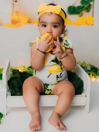 When life gives you lemons, you take cute pictures. This little girl is having a taste of a lemon during her fun photoshoot.