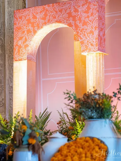 A close-up of the custom-printed arches used in Varun and Nicola's Mehendi decor. The soft pink and orange tones, combined with fresh greenery, created a warm and inviting atmosphere.