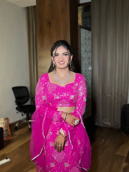 A full view of her unique cocktail outfit. The vibrant pink makeup makes a statement and ties the whole look together.