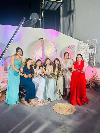 A wonderful group photo with the bride-to-be and her friends and family, all sharing in the joy of the mehndi ceremony.