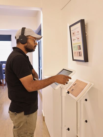 A visitor uses headphones to immerse themselves in the audio-visual component of the Raja Ravi Varma AR experience, demonstrating our commitment to multi-sensory art encounters.