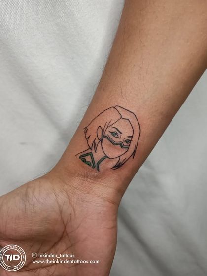 A fine-line tattoo of the Valorant character Viper on the wrist. This is a great example of how we can turn your favorite gaming characters into subtle and stylish ink.