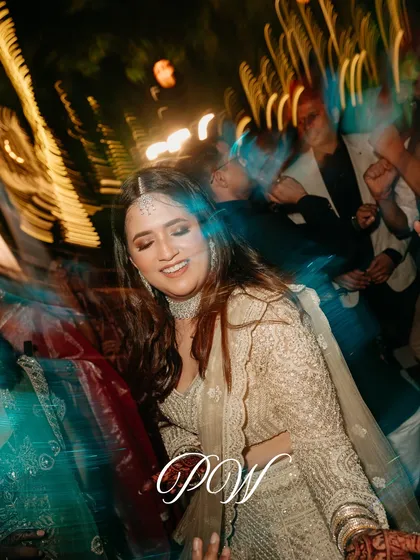 A candid shot of the bride lost in the moment on the dance floor, with motion-blurred lights creating a dynamic and energetic feel.
