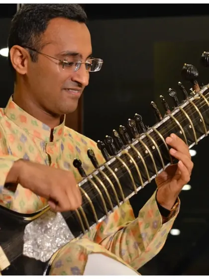 A detailed shot of my hands on the sitar during a house concert, highlighting the intricate technique involved.