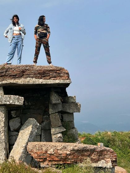 Two trekkers enjoying the view from the very top of the Skandagiri fort ruins.