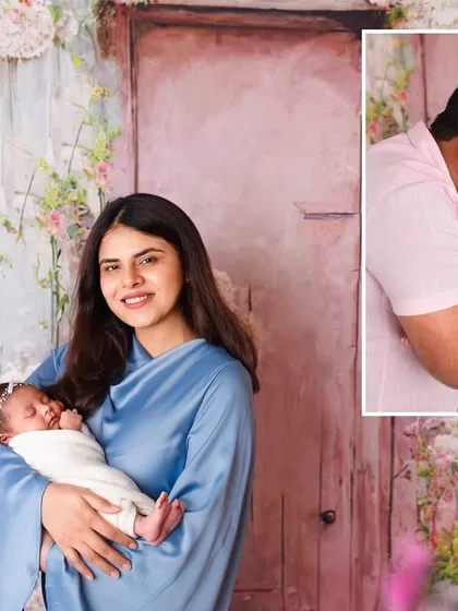 A mother holds her sleeping newborn against a beautiful floral backdrop. This is part of our luxury newborn sessions, where we create truly artistic portraits.