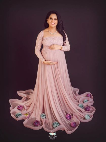 We added a creative touch by arranging flowers within the train of the gown. It adds a unique and whimsical element to this classic maternity portrait.