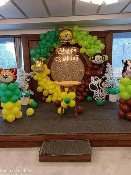 Another view of the wooden stage with the jungle animal balloon decorations.
