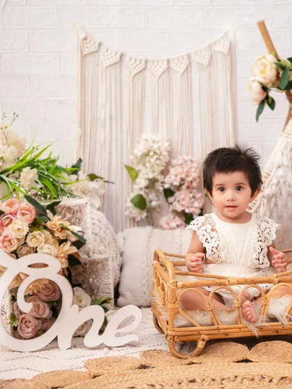 A beautiful first birthday portrait in a neutral boho theme. The lace romper and natural textures create a soft and timeless image.