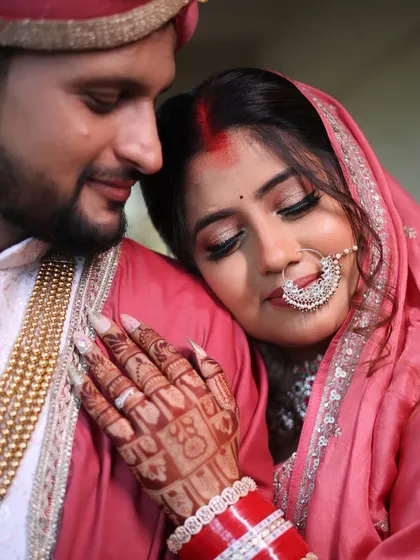 A close-up of the bride resting on the groom's shoulder, a moment of pure love. Her makeup looks soft and romantic.